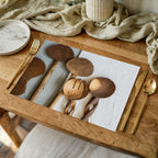 NATURAL BROWN WOODEN SPOONS ON GREY AND WHITE PLACEMAT