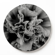 A round printed serving board of a black-and-white photographic print of a close-up peony flower, displayed against a clean white background.