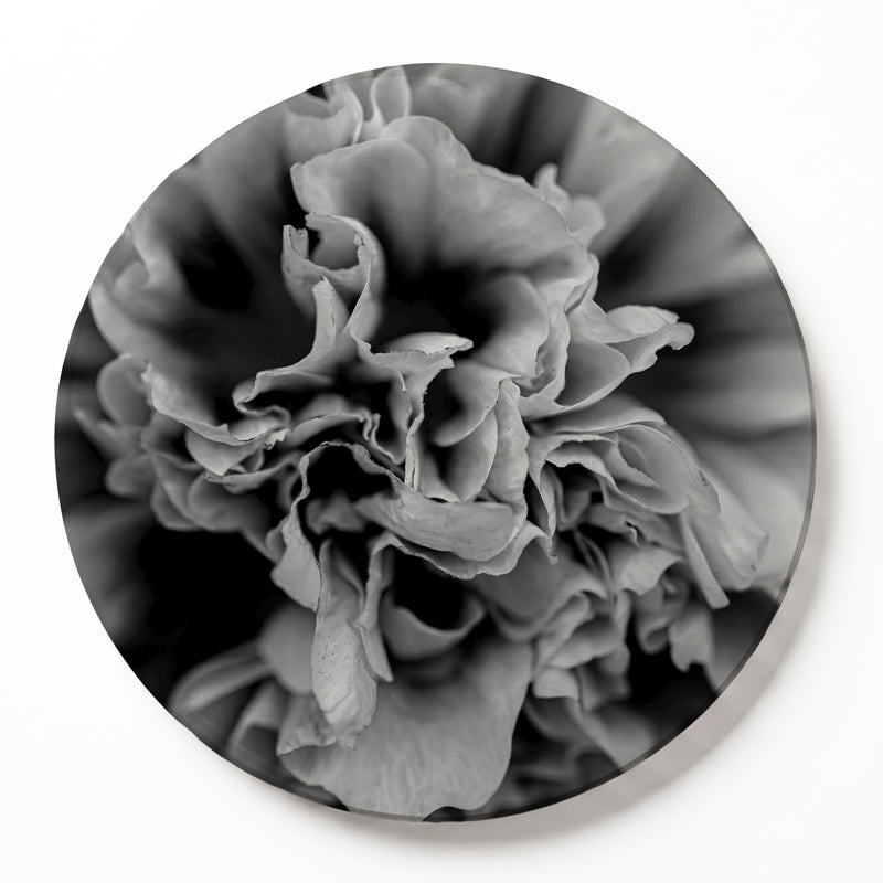 A round printed serving board of a black-and-white photographic print of a close-up peony flower, displayed against a clean white background.