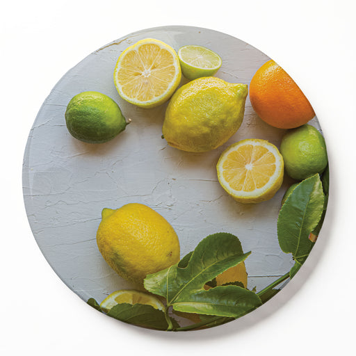 A round wooden serving board featuring a yellow-and-orange citrus-on-white print, displayed on a clean white background.