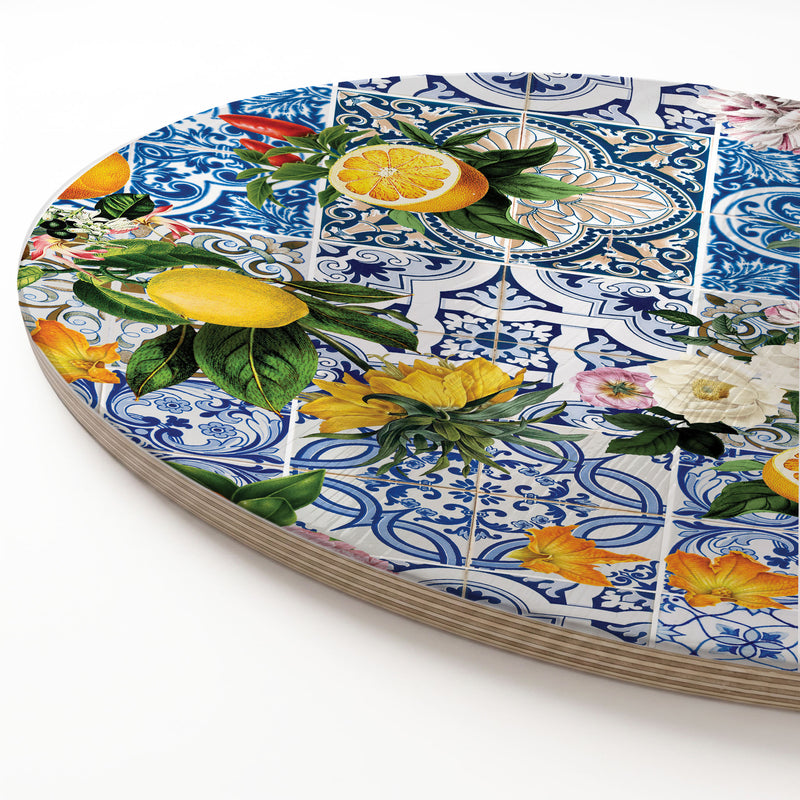 A round wooden serving board featuring a blue Lisbon tile with a lemons-and-flowers print, shown on a clean white background.