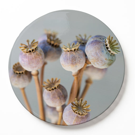 A round wooden serving board featuring a purple giant poppy seed bunch print, set against a clean white background.