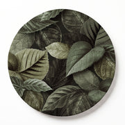 A round wooden serving board featuring an all-over monochromatic green botanical leaf print, shown against a plain white studio backdrop.