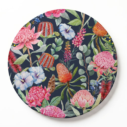 A round printed serving board featuring a vibrant tropical floral pattern with pink, red, and blue flowers on a dark navy background, shown on a clean white surface.