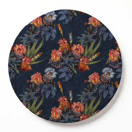 A round printed serving board featuring a dark navy blue background with a vintage-style floral pattern of irises in muted pink, orange, blue-grey, and green.