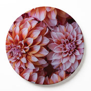 A round serving board featuring a close-up floral print of pink and orange dahlias, shown against a clean white background.