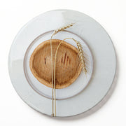 A round wooden serving board featuring a beige wheat-on-wood print on a white background.