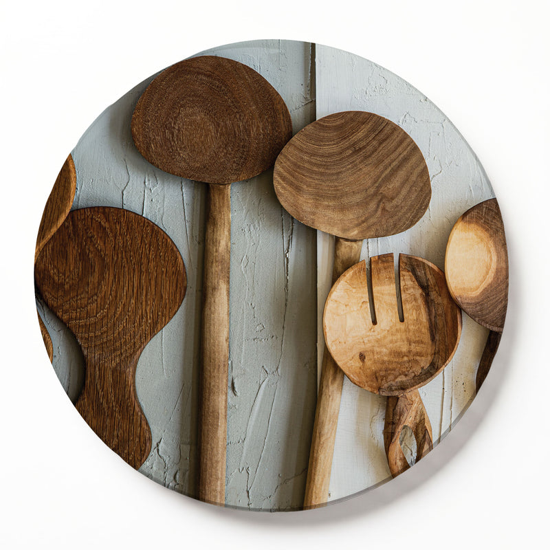 A round wooden serving board featuring a brown wooden spoons print, photographed on a white background.