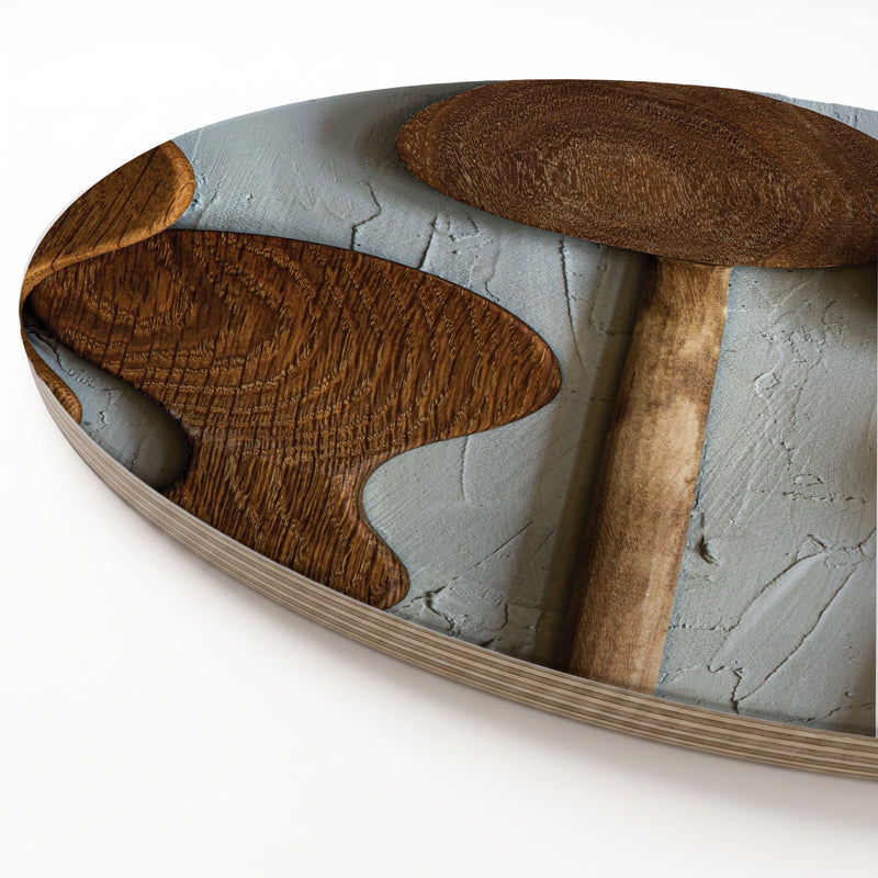 A round wooden serving board featuring a brown wooden spoon print, shown on a white surface.